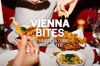 Eslogan «Vienna Bites. Cuisine, Culture, Character» en segundo plano. Comida sobre una mesa.