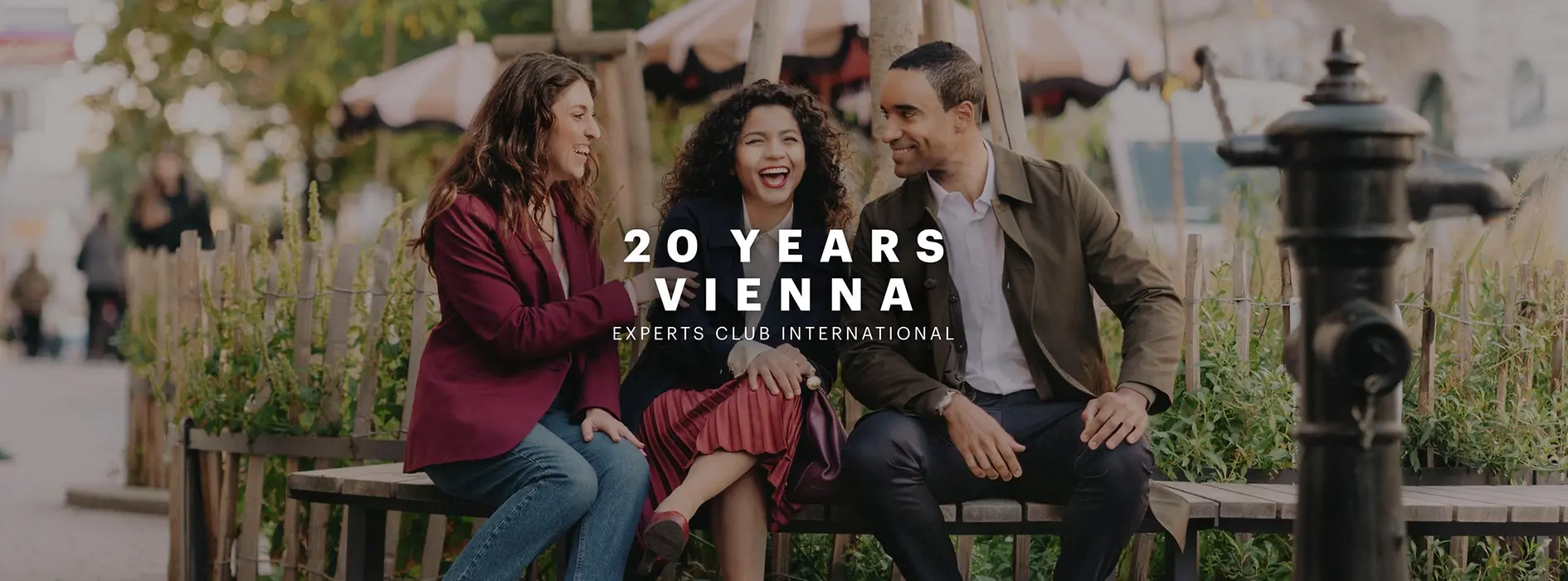 Three people are sitting on a bench and chatting happily.