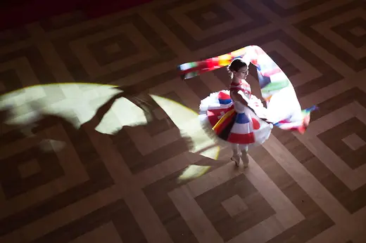 Tänzerin tanzt in einem Kleid mit Länderflaggen