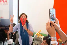 A VECI member poses with a V for Vienna in front of a mobile phone camera