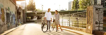 Two cyclists by the Danube Canal