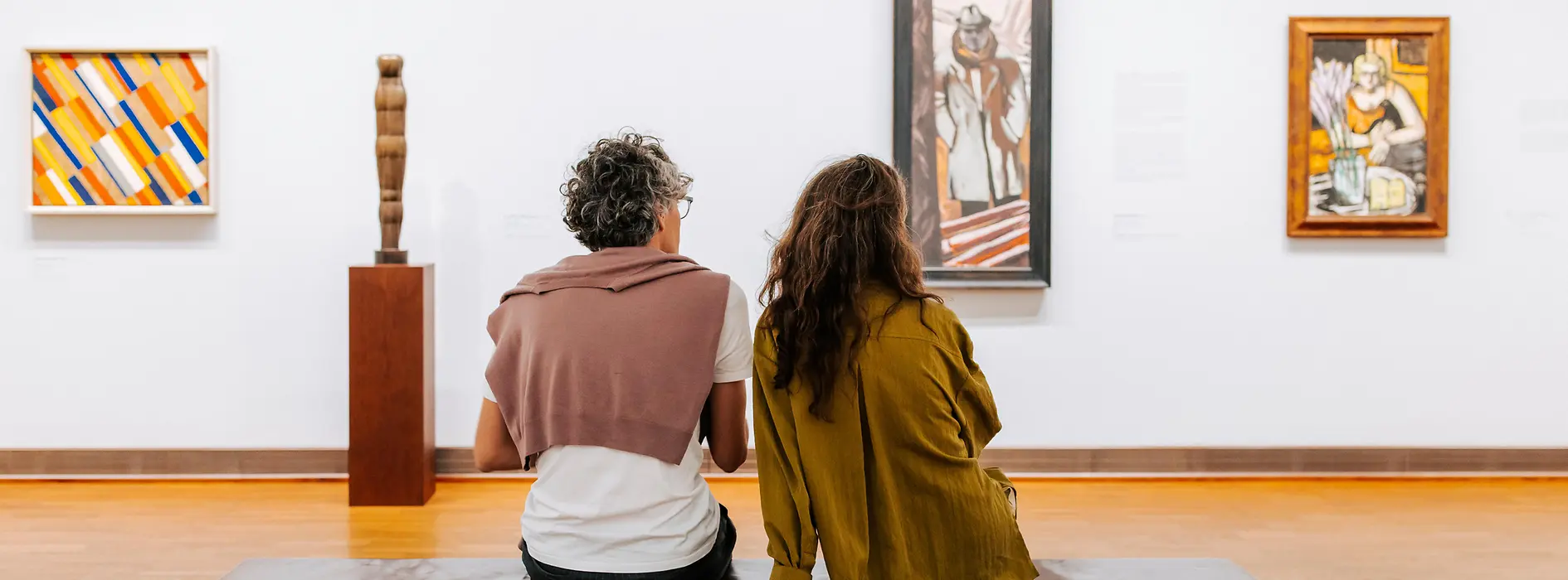 Visita al museo Albertina, dos personas sentadas en un banco mirando arte