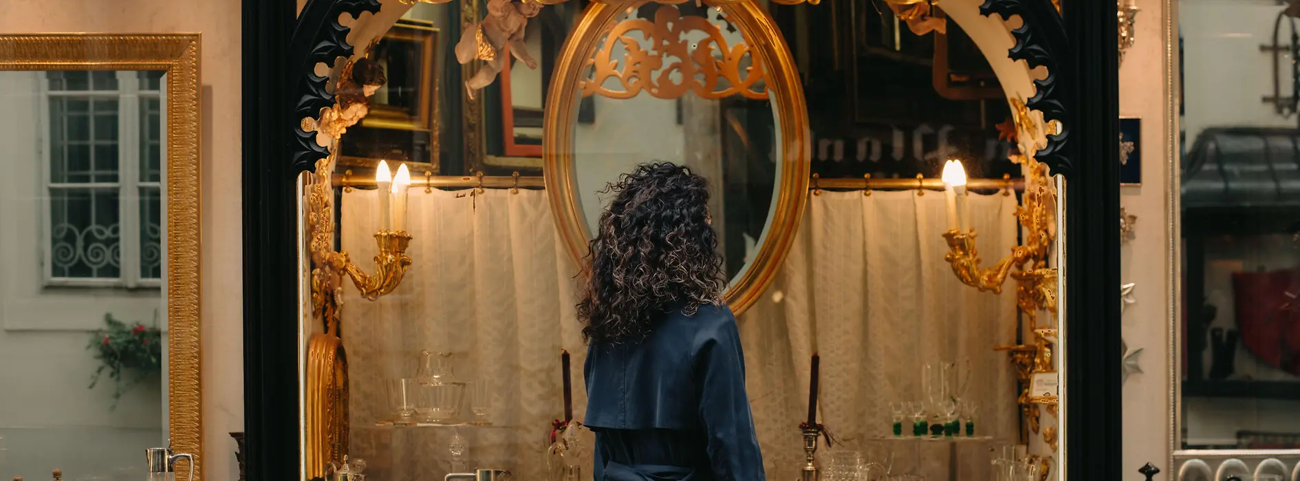 Woman standing in front of a display of antiques