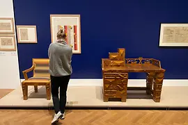 Frau von hinten betrachtet ein Möbelstück