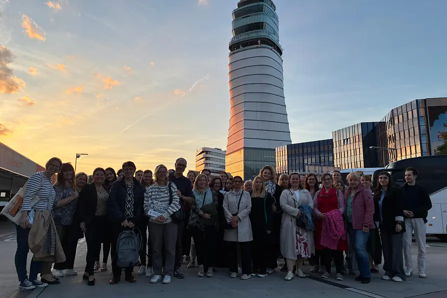 Gruppe Personen vor einem Flughafenturm